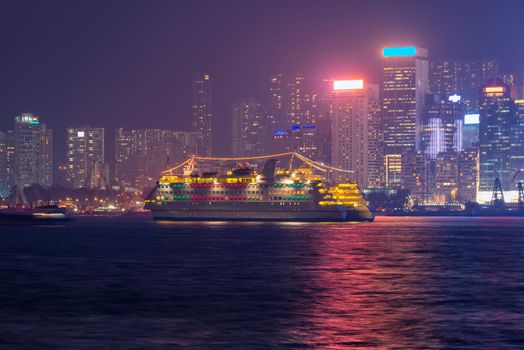 Luxury large touring boat for tourist service in victoria harbor at night view from Kowloon side at Hong Kong.