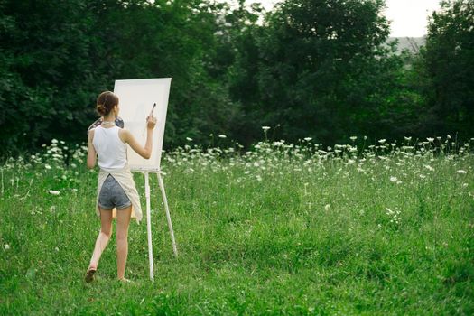 woman artist in aprons paint palette easel nature. High quality photo