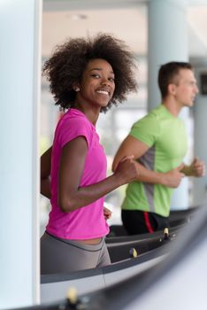 young people exercisinng a cardio on treadmill running machine in modern gym