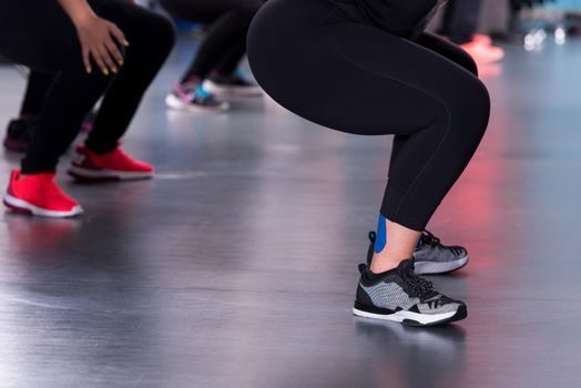 group of young healthy sporty women working out with instructor doing aerobics exercises in a fitness studio fitness, sport, training, gym and lifestyle concept