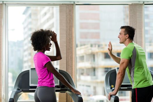 young people exercisinng a cardio on treadmill running machine in modern gym