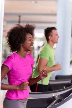 young people exercisinng a cardio on treadmill running machine in modern gym