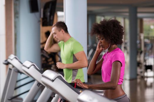 young people exercisinng a cardio on treadmill running machine in modern gym