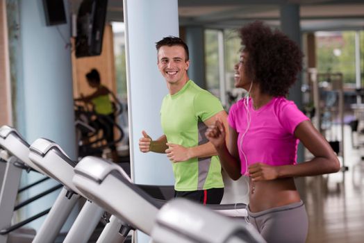 young people exercisinng a cardio on treadmill running machine in modern gym