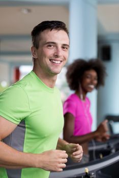 young people exercisinng a cardio on treadmill running machine in modern gym