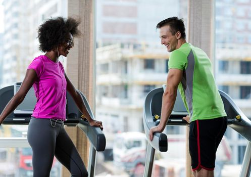 young people exercisinng a cardio on treadmill running machine in modern gym