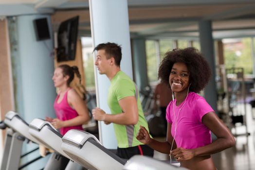 young people exercisinng a cardio on treadmill running chine in modern gym