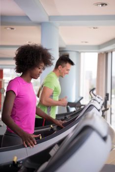 young people exercisinng a cardio on treadmill running chine in modern gym