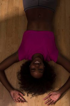 happy african american woman with a curly afro hairstyle in a  gym relaxing after pilates workout