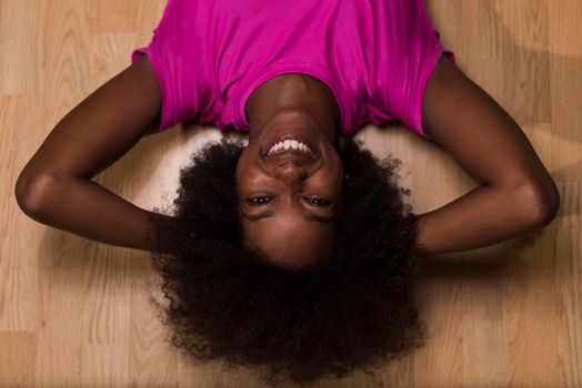 happy african american woman with a curly afro hairstyle in a  gym relaxing after pilates workout