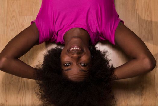 happy african american woman with a curly afro hairstyle in a  gym relaxing after pilates workout