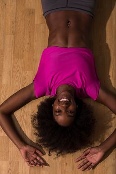 happy african american woman with a curly afro hairstyle in a  gym relaxing after pilates workout