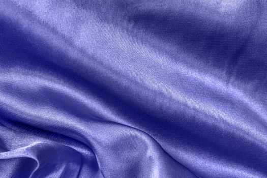 Color of the year 2022 smooth violet blue silk or satin folds closeup. Cloth texture background. Abstract wallpaper. Trendy soft blue backdrop for web design. Luxury twisted fabric backplate