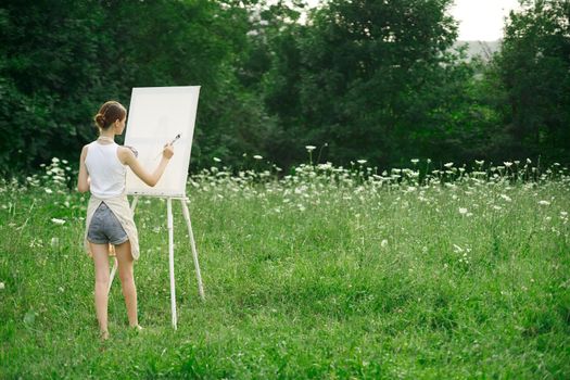 woman artist in aprons paint palette easel nature. High quality photo