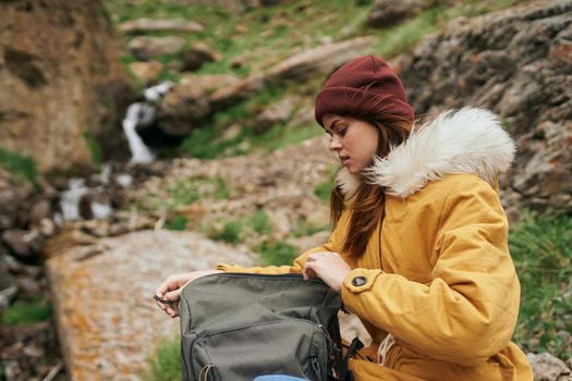 woman in a yellow jacket with a backpack in the mountains travel adventure. High quality photo