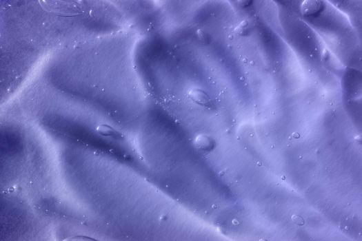 Color of the year 2022. Texture of transparent light violet blue gel with air bubbles and waves on soft background. Concept of skin moisturizing and prevention of covid. Liquid beauty product closeup