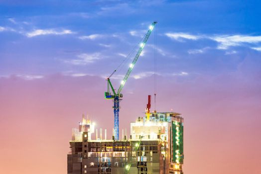 Heavy duty industrial crane busy operate at construction site for new complex infrastructure project.