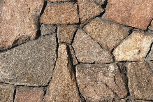 Stone wall of granite close-up, texture, background.