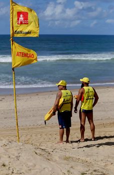 salvador, bahia, brazil - june 26, 2019: Lifeguards observe ocean waves moving on a beach in Salvador city.