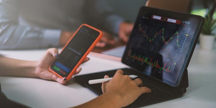 Business team working together and training to analyze technical price graph and indicator. Chart and stock trading computer screen.