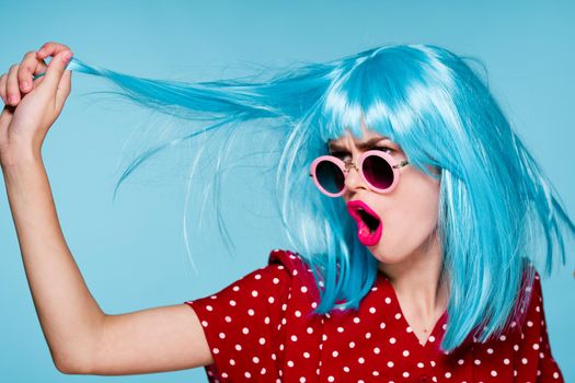 emotional glamorous woman on blue wig fashion glasses posing. High quality photo