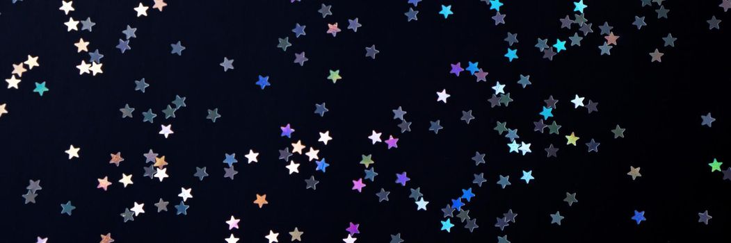 Festive black paper background with many many silver stars. Christmas, New Year or Birthday theme concept. An ideal backdrop for your banner or web design. Banner for happy holidays presentation