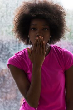 portrait of young afro american woman in gym on workout break while listening music on earphone  and dancing  rainy day and bad weather outdooor