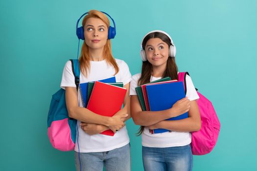 thoughtful private teacher and kid in earphones holding textbook and school bag, estudy.