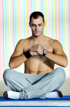 young man exercise and practice yoga fitness  in lotus position indoor