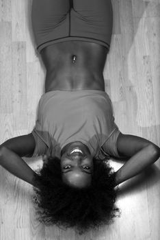 happy african american woman with a curly afro hairstyle in a  gym relaxing after pilates workout