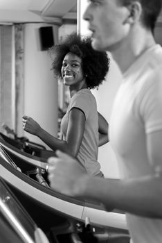 young people exercisinng a cardio on treadmill running chine in modern gym