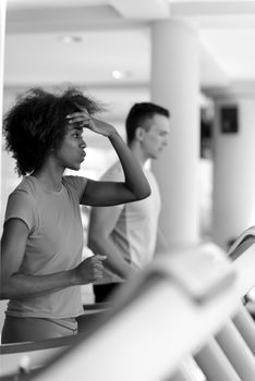 young people exercisinng a cardio on treadmill running chine in modern gym