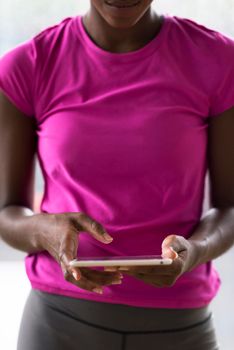 beautiful african american woman using tablet computer from home while rain and bad weather is outdoor