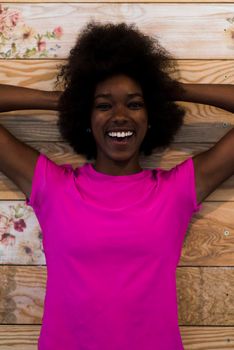 portrait of cute african american woman with afro hairstyle while  posing against old retro wooden background