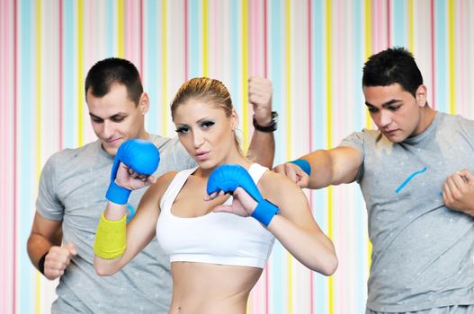 group of young adults exercise in fitness club with trainer