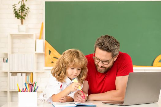 webinar video lesson. online education on laptop. father and son use modern communication technology. family blog. childhood and parenthood. concentrated boy study with private teacher.