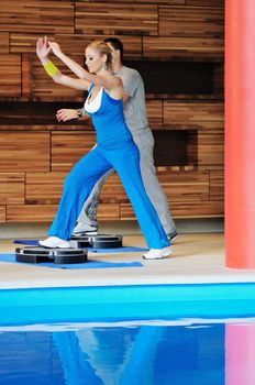 group of young adults exercise in fitness club with trainer