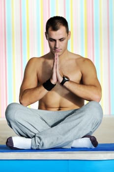 young man exercise and practice yoga fitness  in lotus position indoor