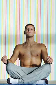 young man exercise and practice yoga fitness  in lotus position indoor