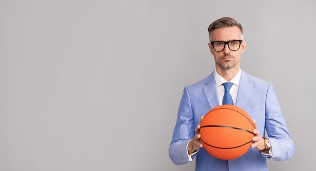 successful man with basketball ball. sport and business success. activity for confident boss. mature businessman in formalwear and glasses.