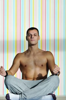 young man exercise and practice yoga fitness  in lotus position indoor