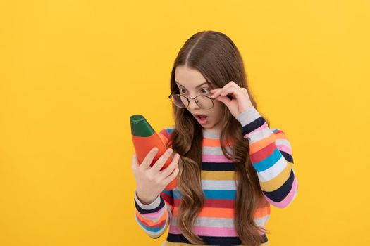 amazed teen girl long hair in glasses looking at shampoo bottle, haircare.