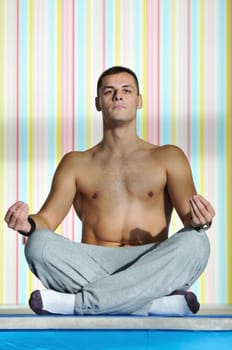 young man exercise and practice yoga fitness  in lotus position indoor