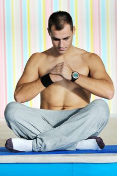 young man exercise and practice yoga fitness  in lotus position indoor in fitness club