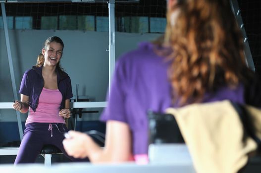 young woman relaxing from working out in a gym by listening music on mp3 player