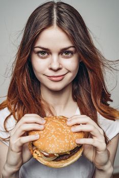 woman with a hamburger in her hands a snack fast food close-up. High quality photo