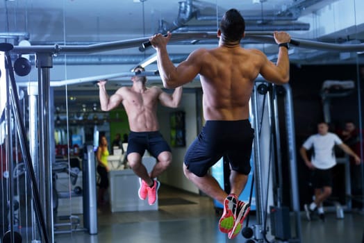 Strong handsome man exercising at the gym