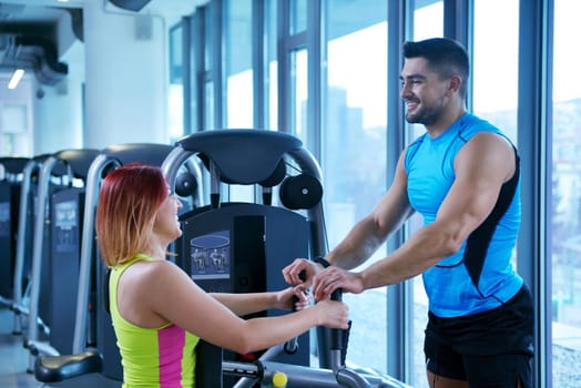 Gym woman exercising with her personal trainer