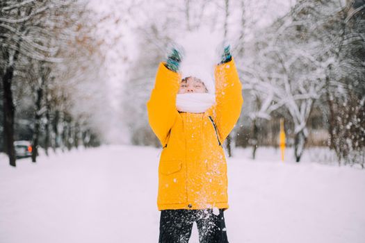 The boy throws snow in winter lifestyle . Winter walks. An article about children's winter leisure. Entertainments