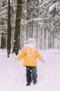 The boy throws snow in winter lifestyle . Winter walks. An article about children's winter leisure. Entertainments